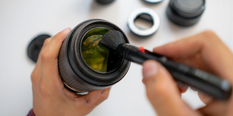 top view of a master repair modern camera equipment, cleaning dust on the lenses
